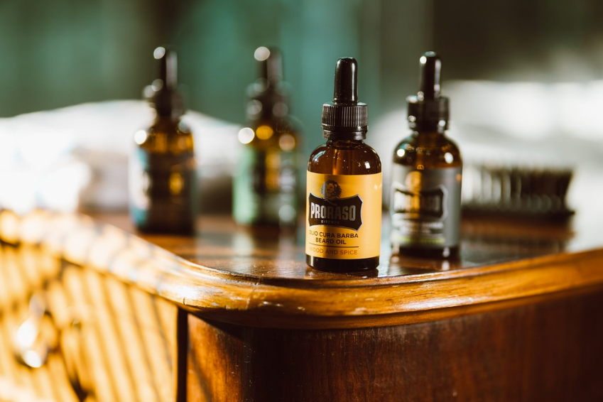 Olejek do brody Proraso - 4 buteleczki olejki stojące na drewnianym blacie